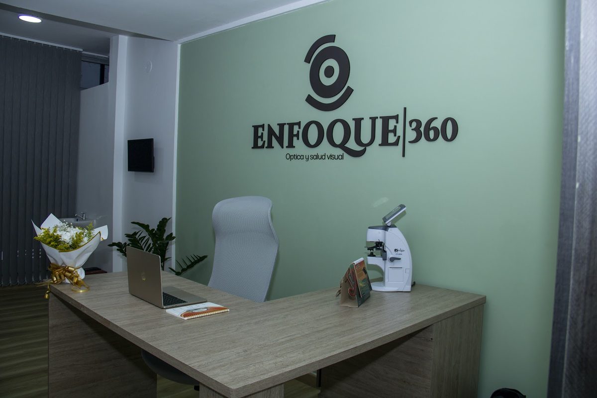 Recepción de Enfoque 360, con el logo de la marca en la pared verde